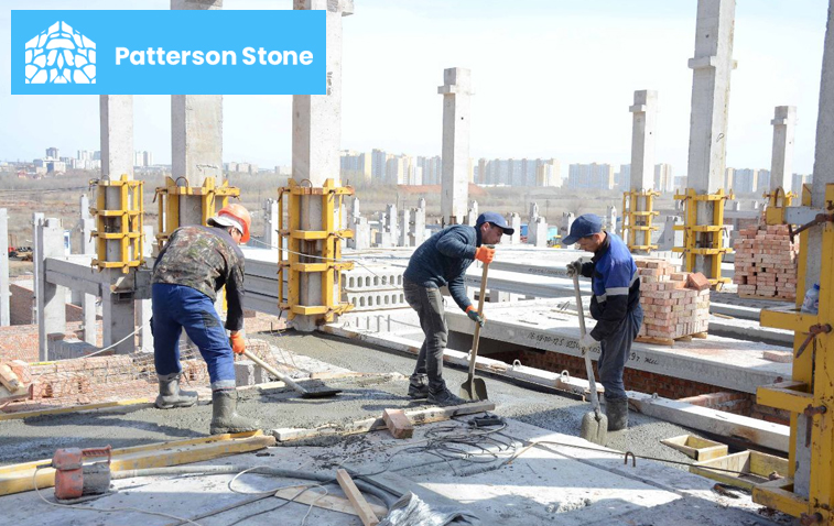 Workers laying concrete foundation at a construction site